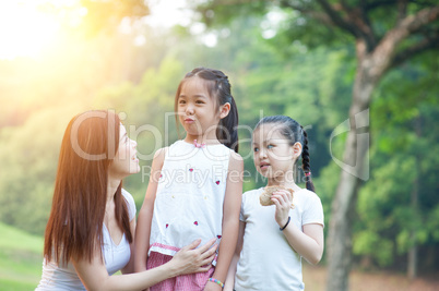 Mother and daughters portrait at outdoors park.