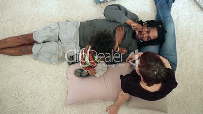 Diverse family with toddler boy lounging at home