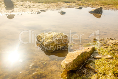 England, UK on a spring morning. Rocks and pools on sandy beach.
