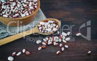 Beans in a wooden spoon on a wooden table