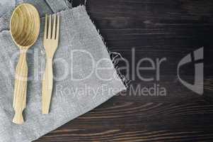 Wooden spoon and fork on gray napkin