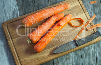 Whole carrots on a kitchen cutting board