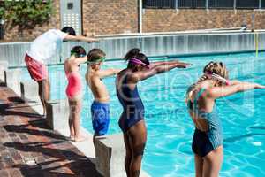Instructor and little swimmers preparing to jump in pool