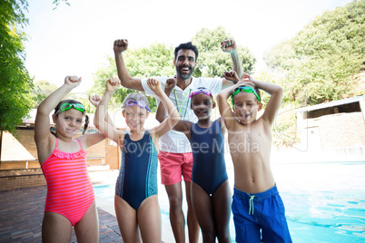 Portrait of cheerful male instructor with little swimmers