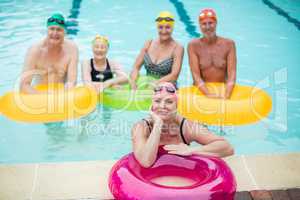 Swimmers with inflatable rings in pool
