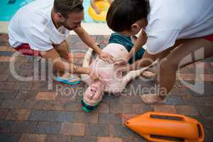 Rescue workers saving unconscious senior man at poolside