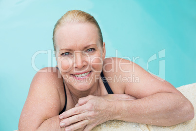 Mature woman leaning on poolside