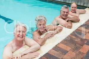 Portrait of swimmers leaning on poolside