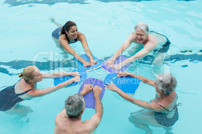 Senior swimmers with trainer enjoying in swimming pool