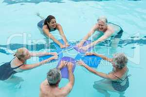 Senior swimmers with trainer enjoying in swimming pool