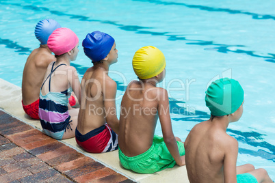 Friends sitting at poolside