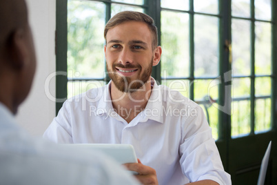 Smiling businessman looking at colleague in restaurant