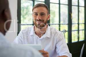 Smiling businessman looking at colleague in restaurant