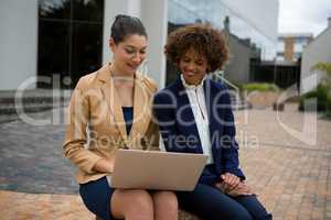 Two businesswomen using laptop