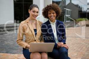 Portrait of two businesswomen using laptop