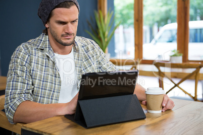 Man using digital table while having coffee in cafe