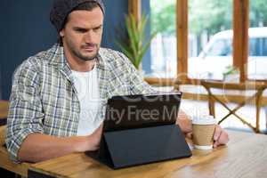 Man using digital table while having coffee in cafe