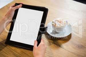Cropped image of woman using digital tablet in cafe