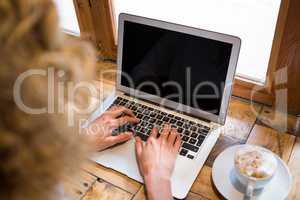 High angle view of woman using laptop in coffee shop