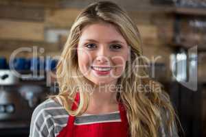 Portrait of smiling young female barista in coffee shop
