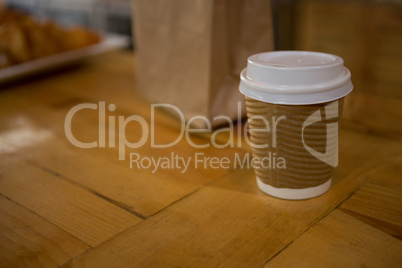 Disposable coffee cup on table in cafe