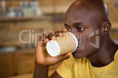 Close-up of young man drinking coffee in cafe