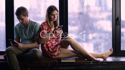 Couple ignoring each other using mobile phones