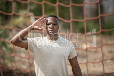 Military soldier giving salute during obstacle course