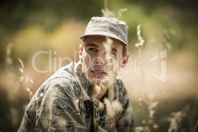 Thoughtful military soldier relaxing in grass