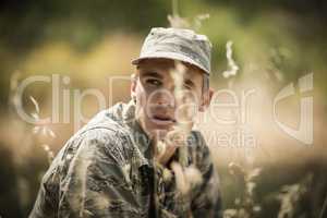 Thoughtful military soldier relaxing in grass