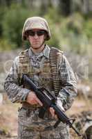 Confident military soldier standing with rifle