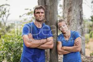 Tired man and woman standing with arms crossed during obstacle course