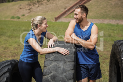 Smiling fit man and woman interacting with each other during obstacle course