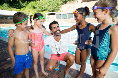 Instructor with little swimmers standing at poolside