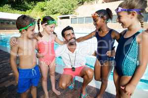 Instructor with little swimmers standing at poolside