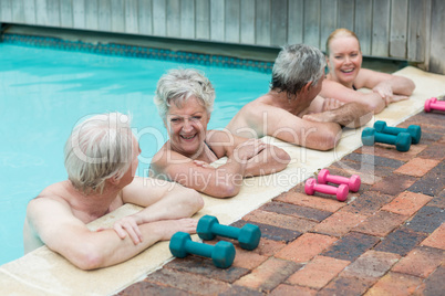 Cheerful swimmers leaning on poolside