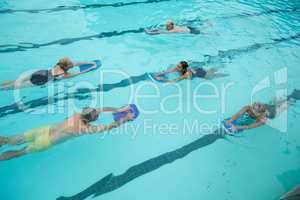 Trainer with senior swimmers swimming in pool