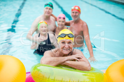 Senior woman by inflatable rings with friends