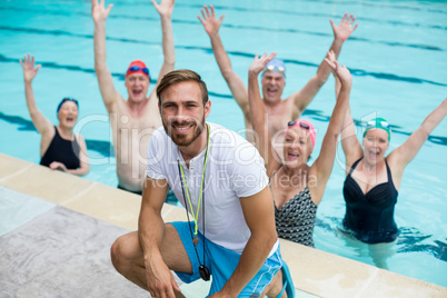 Instructor with carefree senior swimmers in pool