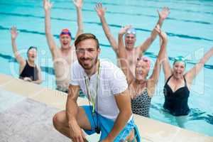 Instructor with carefree senior swimmers in pool