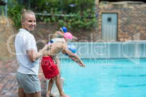 Cheerful instructor monitoring time at poolside