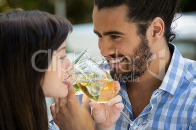 Happy man and woman drinking wine in park