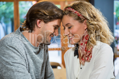 Romantic couple sitting head to head in coffee shop