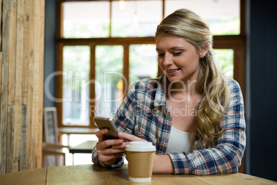 Beautiful woman using mobile phone in cafe