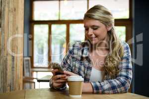 Beautiful woman using mobile phone in cafe