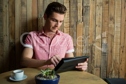 Man using tablet computer at table in coffee house