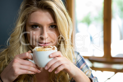 Beautiful young woman having coffee in cafe