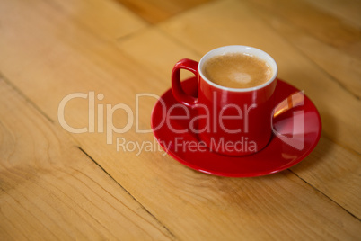 Red cup and saucer on table in coffee shop
