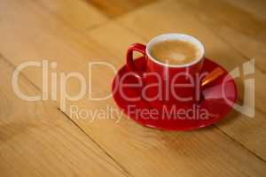 Red cup and saucer on table in coffee shop