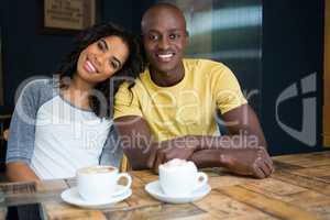 Happy loving couple sitting at table in coffee shop